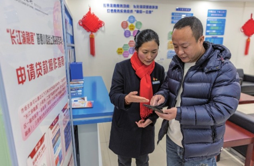 為支持中小微企業等經營主體發展,中國人民銀行重慶市分行聯動當地政府及轄區金融機構,探索在經營主體集中區域建立金融服務港灣。圖為金融服務港灣工作人員指導前來咨詢的商戶通過線上融資服務平臺申請貸款。新華社