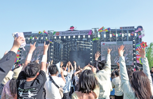 近日,2024北京超級草莓音樂節(jié)在北京世園公園飛行營地開幕,觀眾在現(xiàn)場觀看演出。新華社