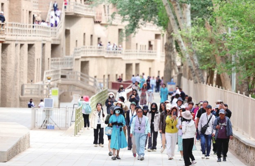 入夏以來,甘肅省敦煌市進(jìn)入旅游旺季。圖為游客在莫高窟參觀游覽。新華社