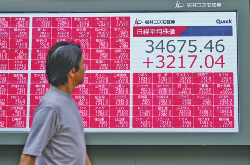 在8月5日暴跌之后,日本東京股市6日震蕩反彈。圖為8月6日,行人走過位于日本東京的電子股指顯示屏。新華社